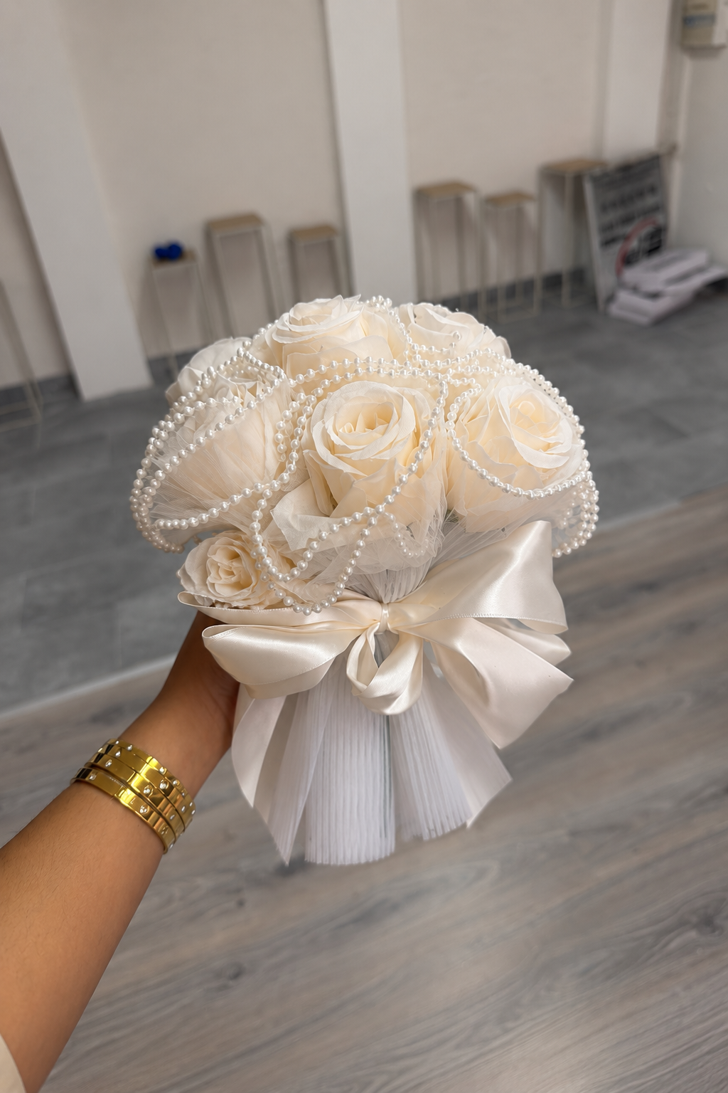 Bouquet de mariée Divas, ruban satin ivoire et papier plissé, vue de côté tenu à la main
