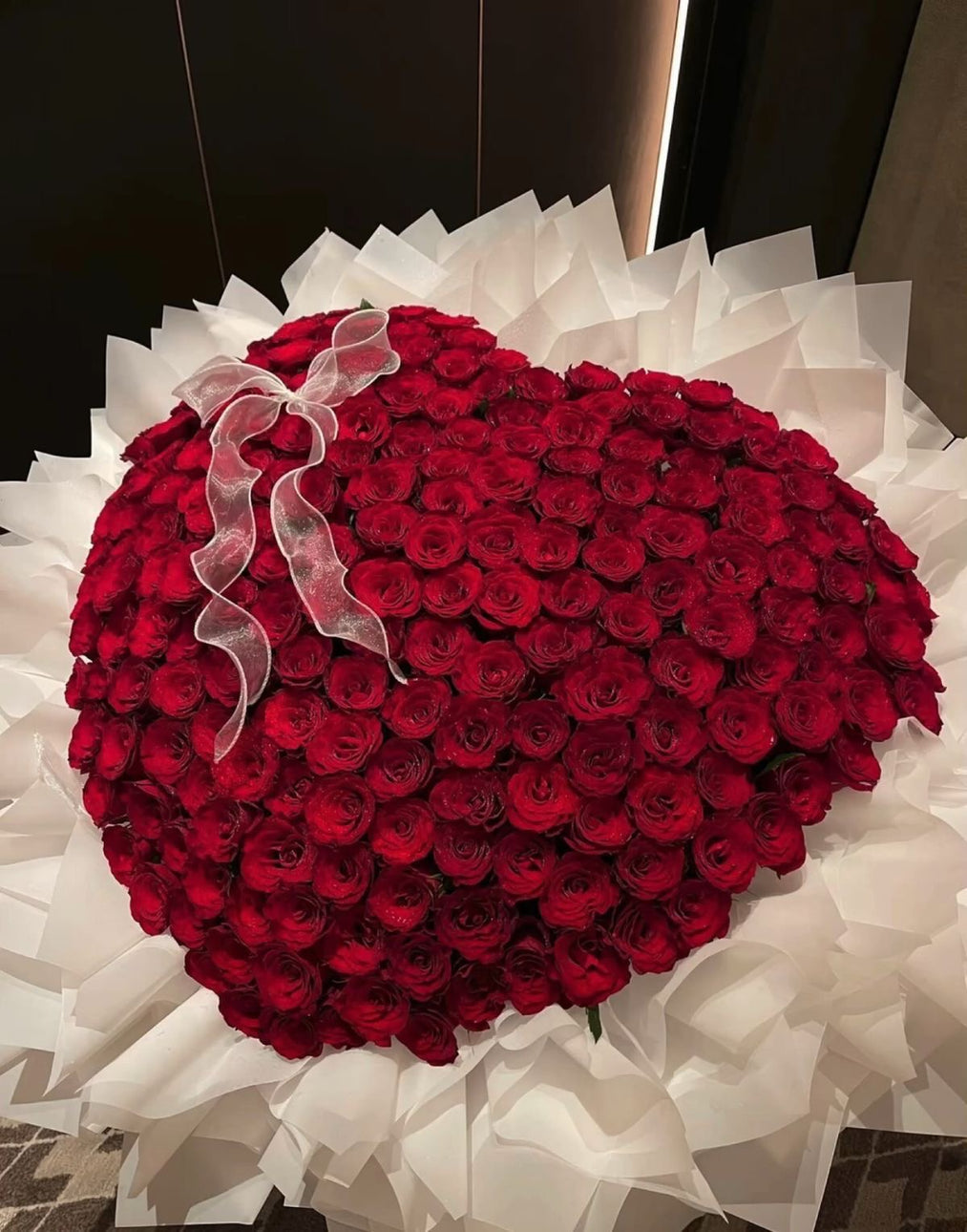 Bouquet SEYA de roses rouges en forme de cœur posé en intérieur