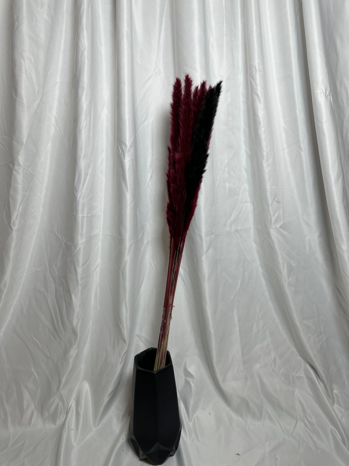 un bouquet de pampas aux teintes profondes de noir et de rouge bordeaux