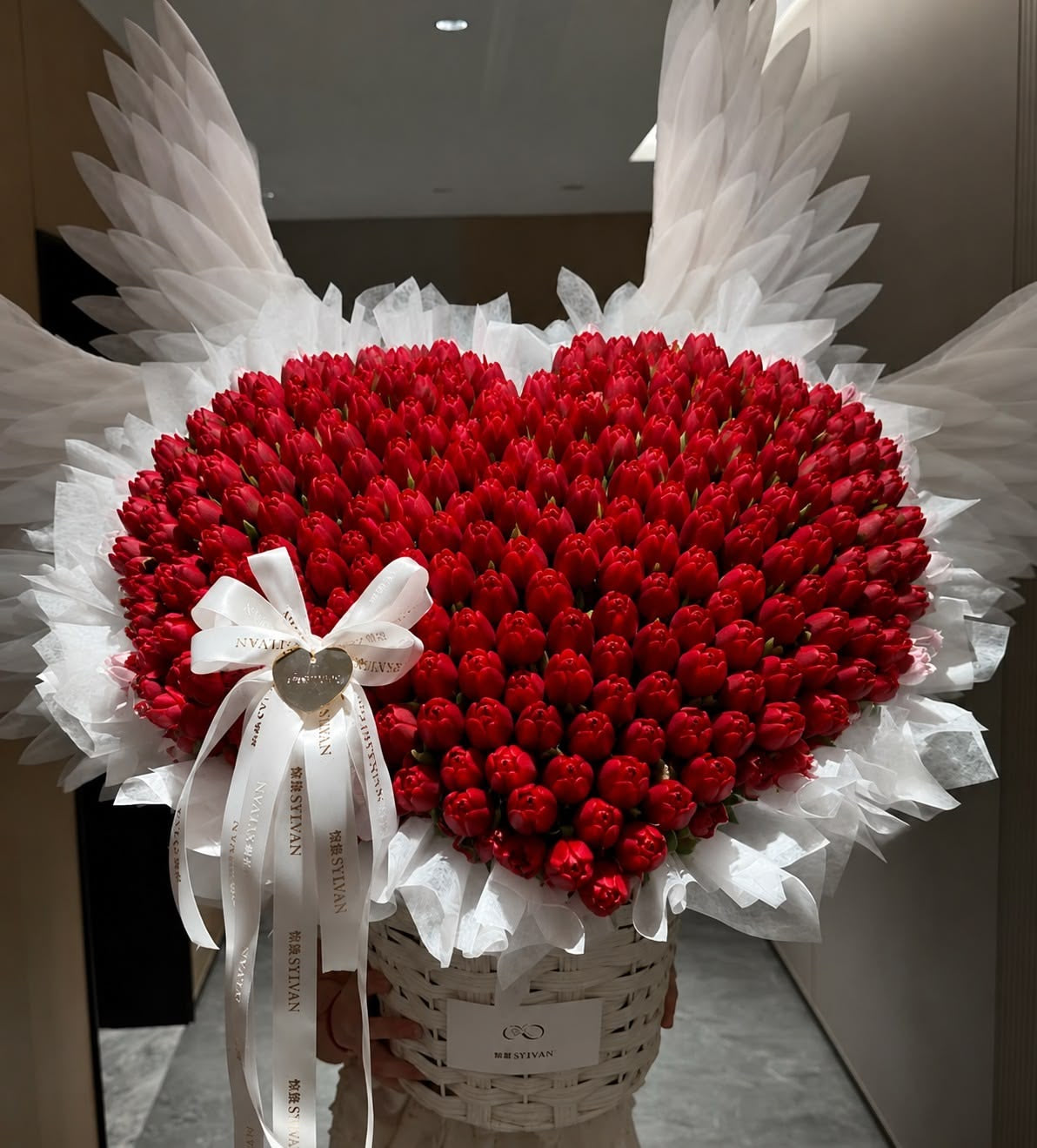 Cœur AMORE de roses éternelles rouges et ailes blanches en ambiance sombre