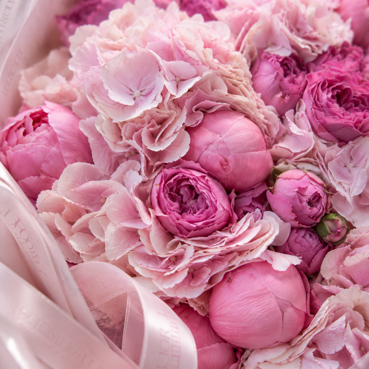 Gros plan sur les hortensias et pivoines roses du bouquet ANA