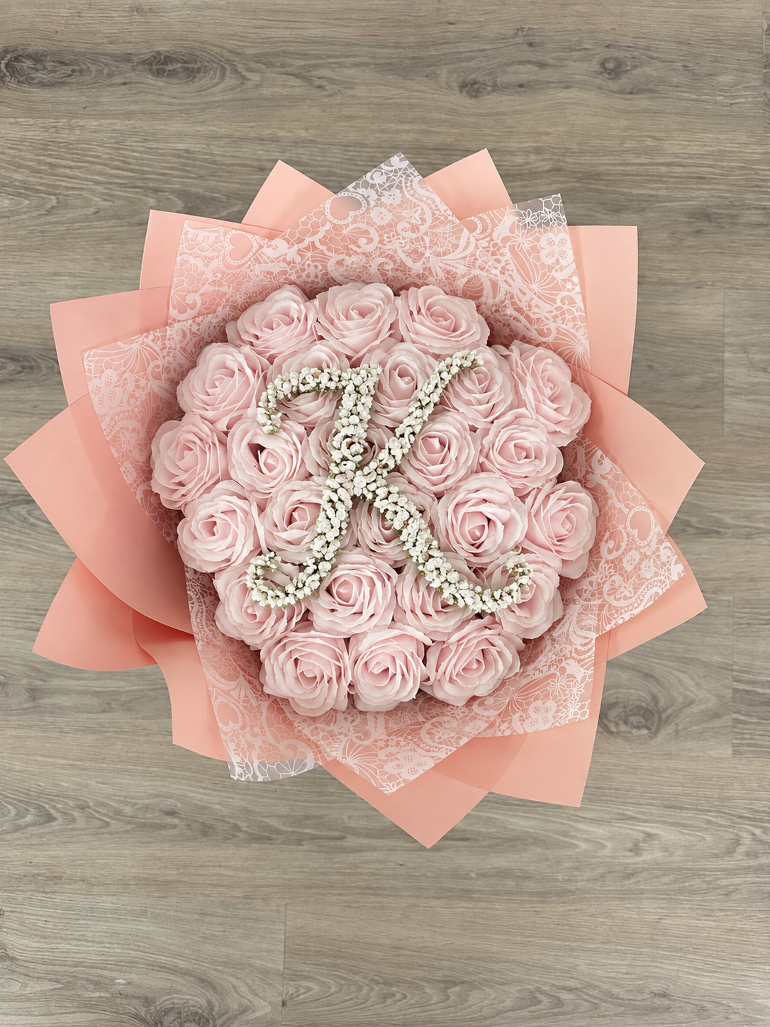 Bouquet ANISA de 25 roses éternelles rose poudré posé sur fond neutre