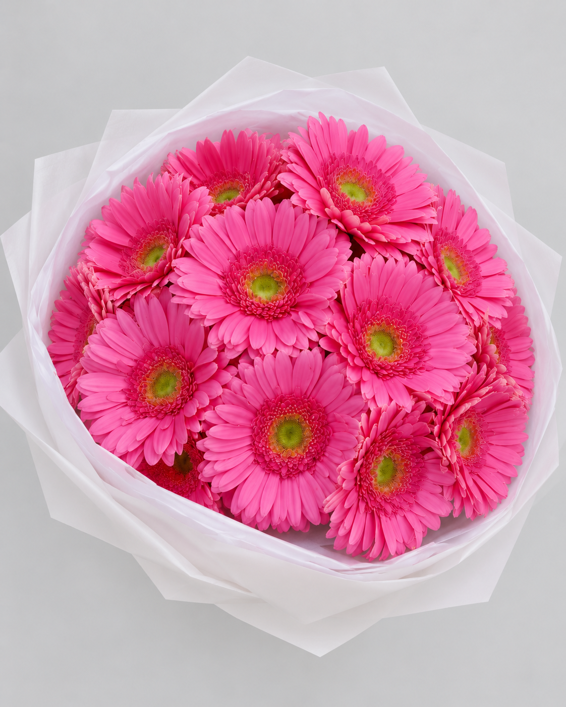 Bouquet Alinea de gerberas roses vu du dessus dans son papier blanc