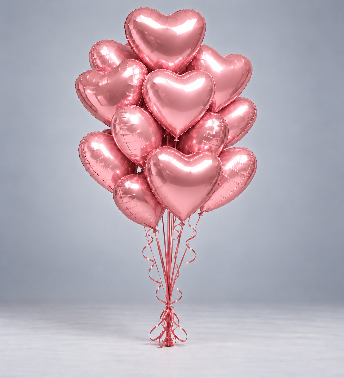 Bouquet de ballons cœurs roses gonflés à l'hélium, avec rubans roses, fond gris