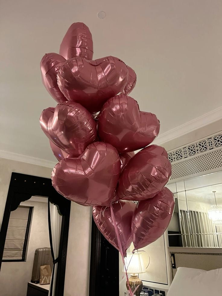 Bouquet de ballons cœurs rose gold dans une chambre
