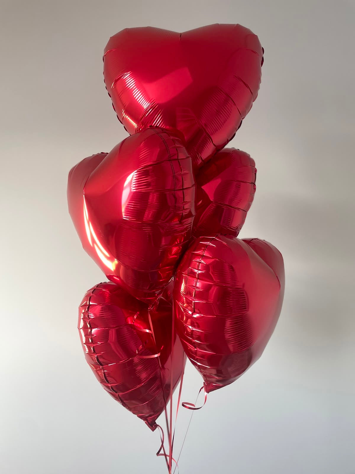 Cinq ballons cœur rouges love gonflés à l'hélium, photo réelle