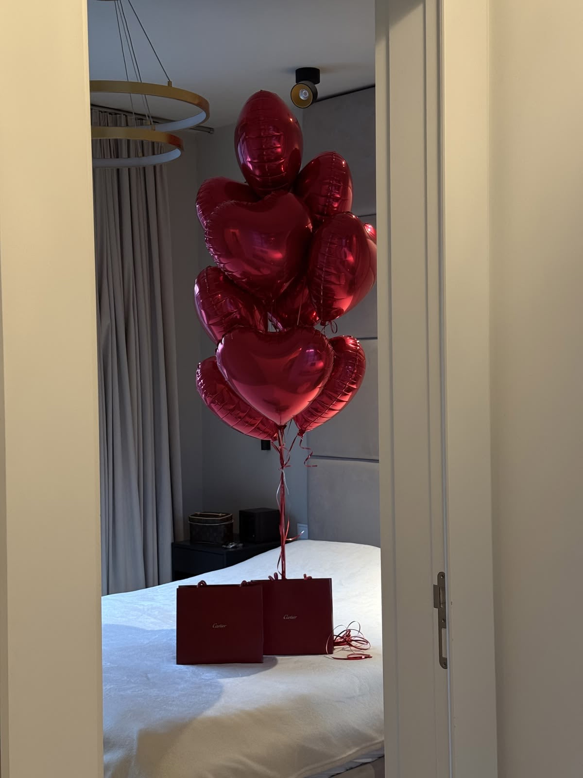 Bouquet de ballons cœur rouges love en décoration surprise dans une chambre