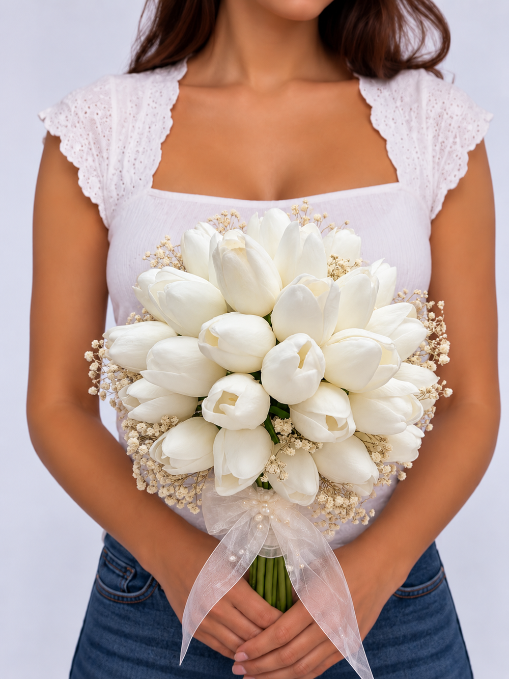 Bouquet de mariée Roméo, tulipes blanches et gypsophile tenu à deux mains