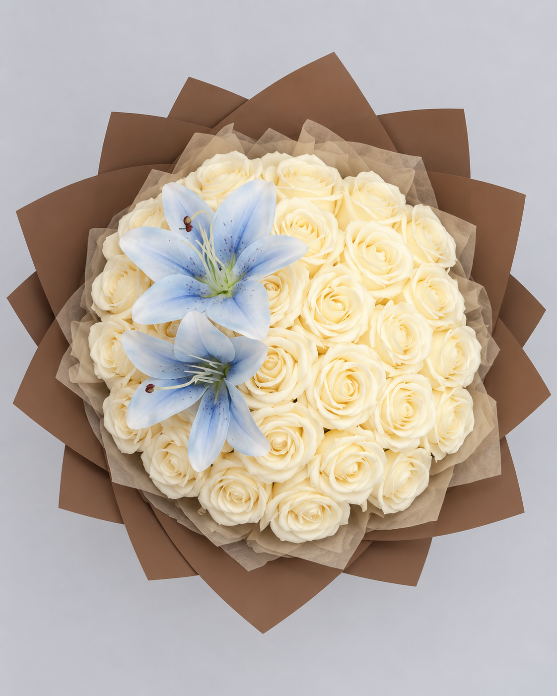 Bouquet Vaea vu du dessus, roses éternelles vanille et deux lys bleu ciel