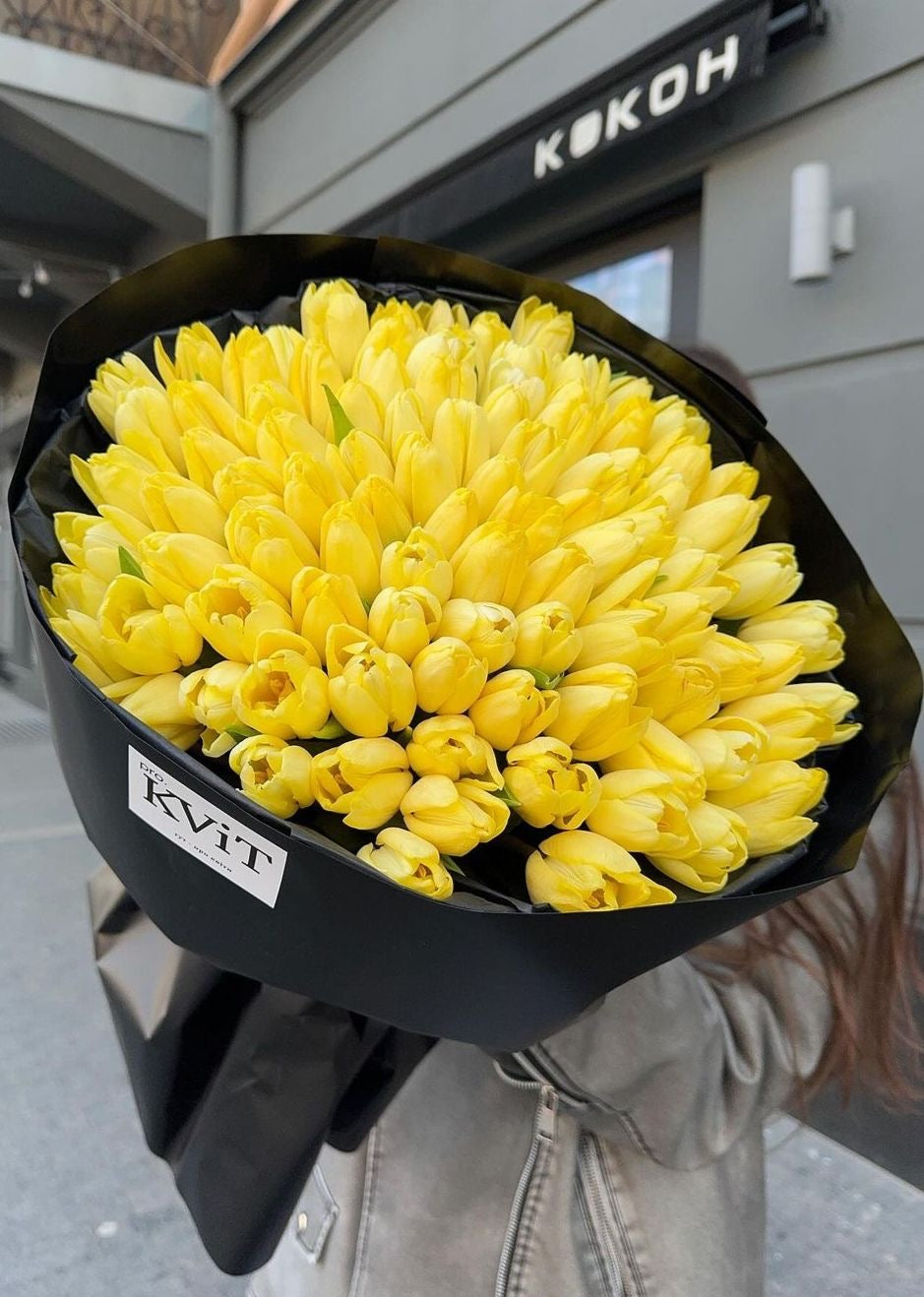 Bouquet Zoe de tulipes jaunes porté dans la rue, photo réelle