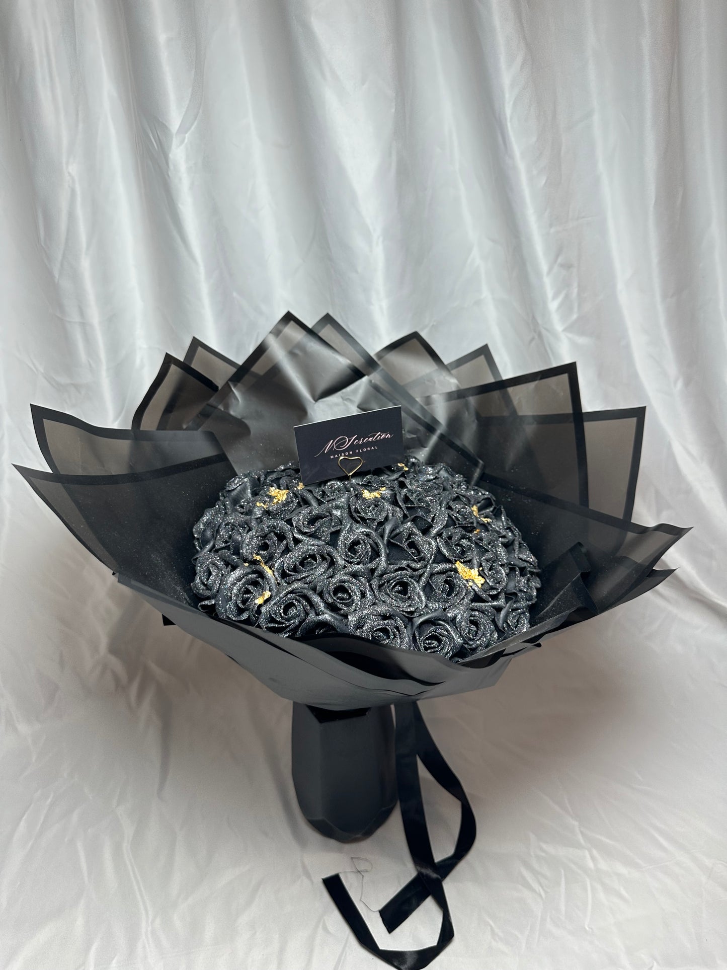 bouquet de roses noirs scintillants avec feuille d'or et emballage noir