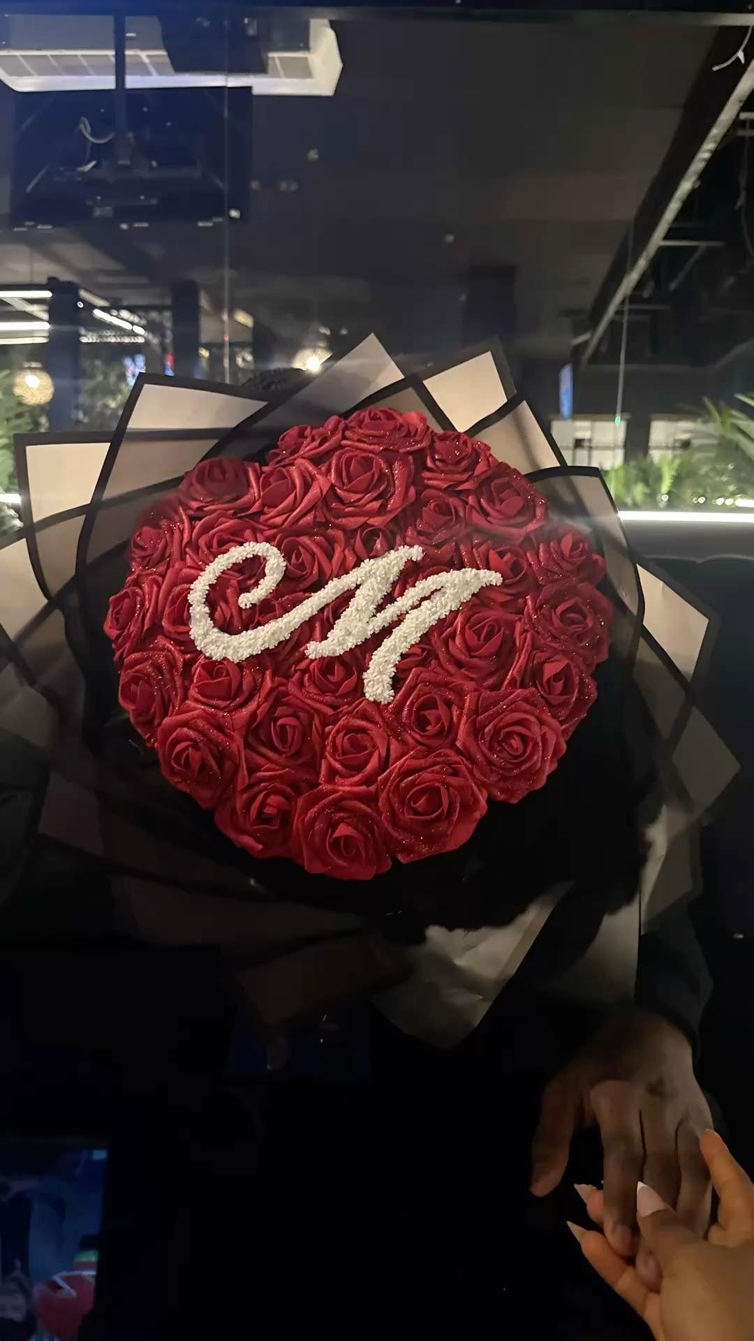 Bouquet CHIRA de roses éternelles rouges avec lettre perlée en ambiance sombre