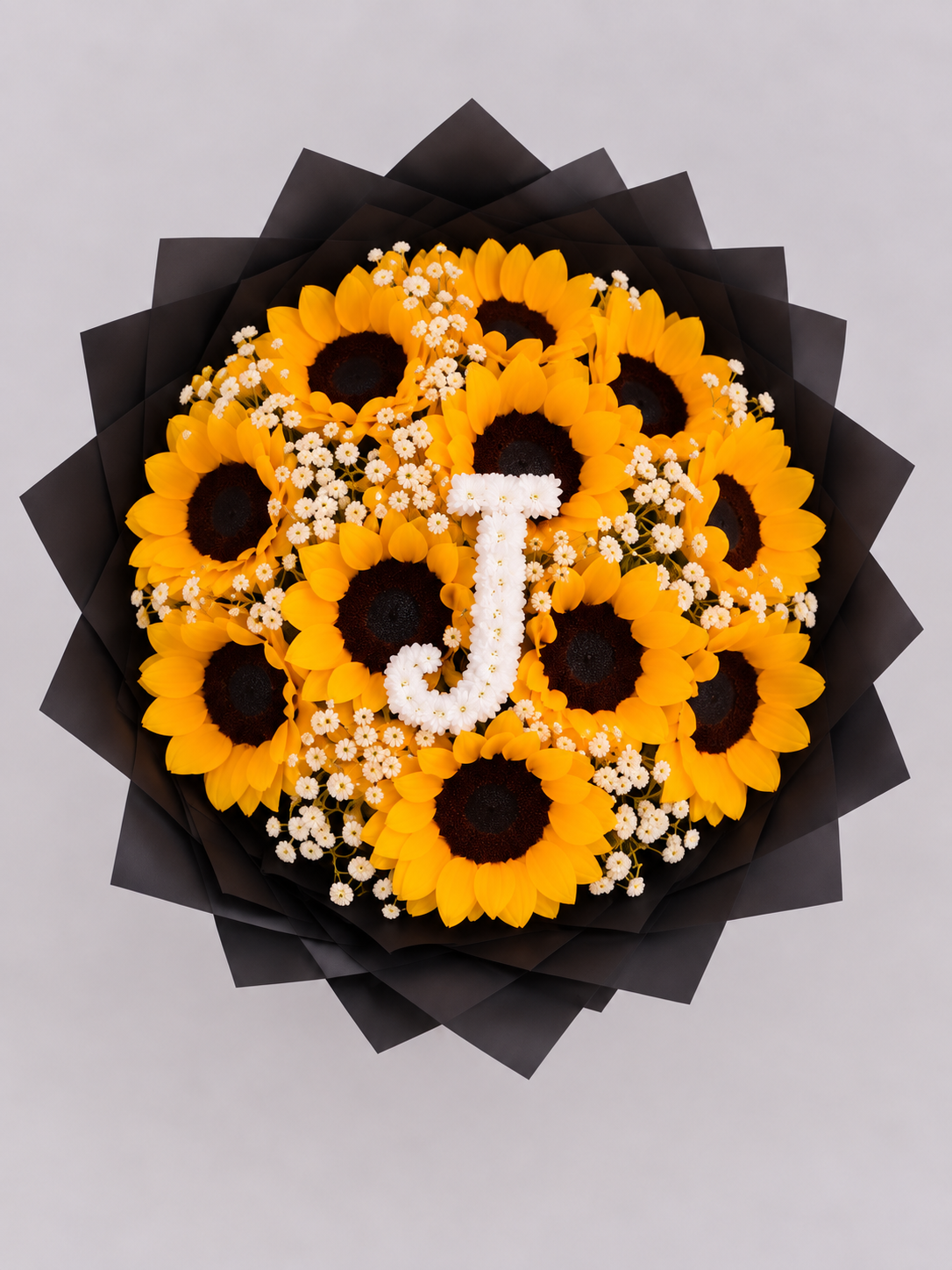 Bouquet Chloé de tournesols avec lettre J en gypsophile vu de dessus, papier noir