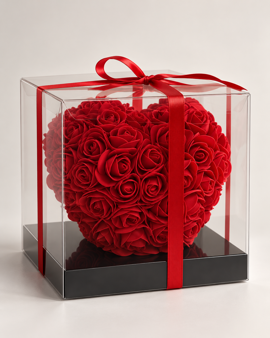 Cœur de roses artificielles rouges Coup de cœur fleuri, boîte transparente sur socle noir, vue de trois quarts