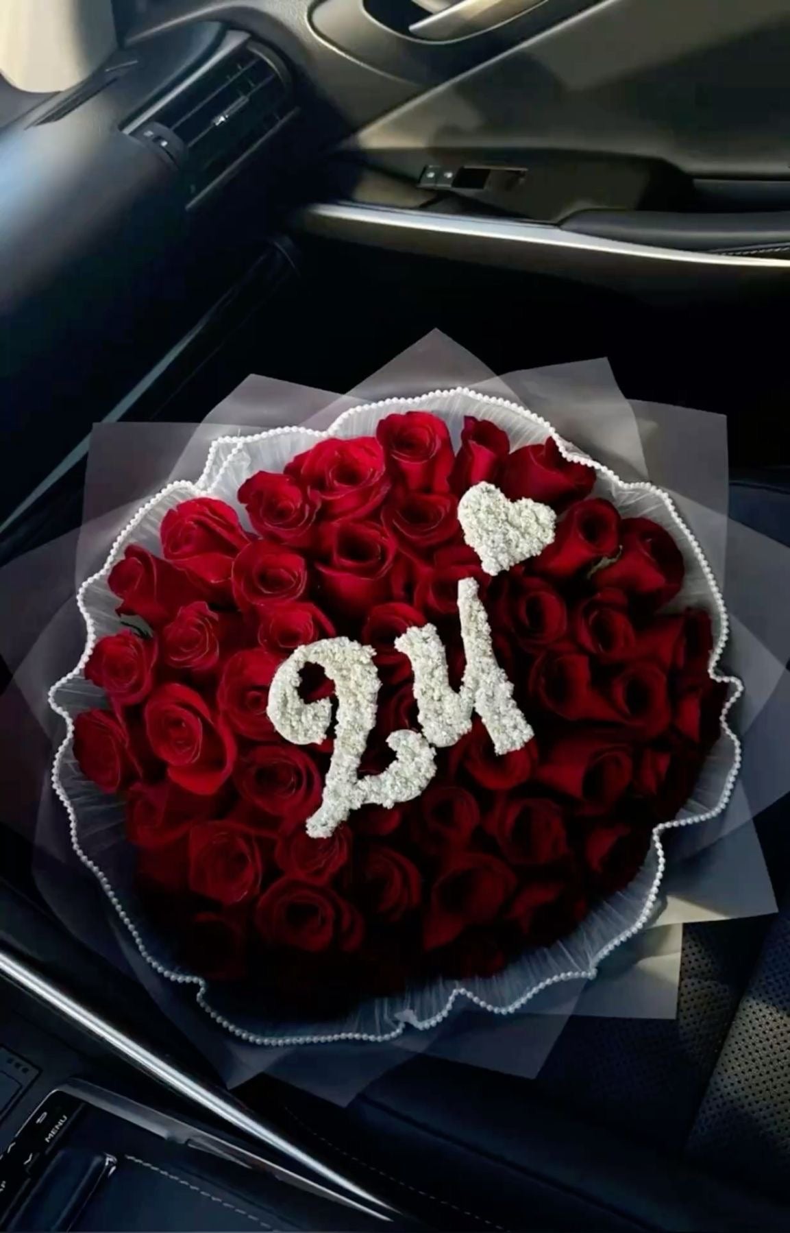 Bouquet Demi de roses rouges avec chiffre 24 et petit cœur sur un siège de voiture