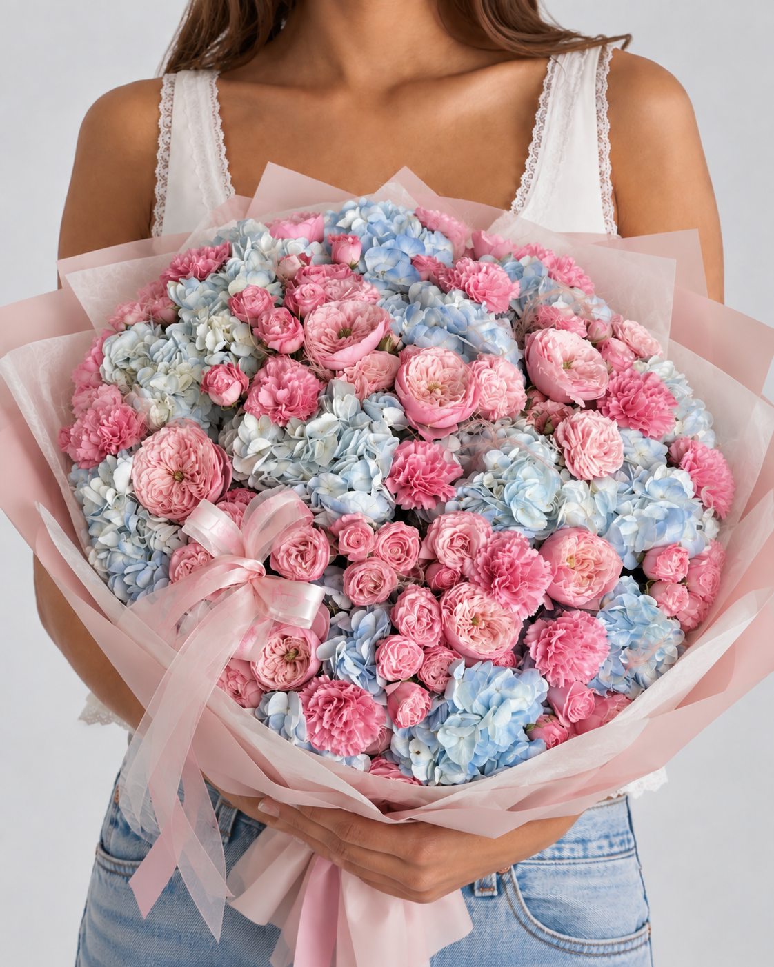 DOROTHÉ, bouquet d'hortensias bleus, œillets roses et renoncules fraîches, tenu à la main