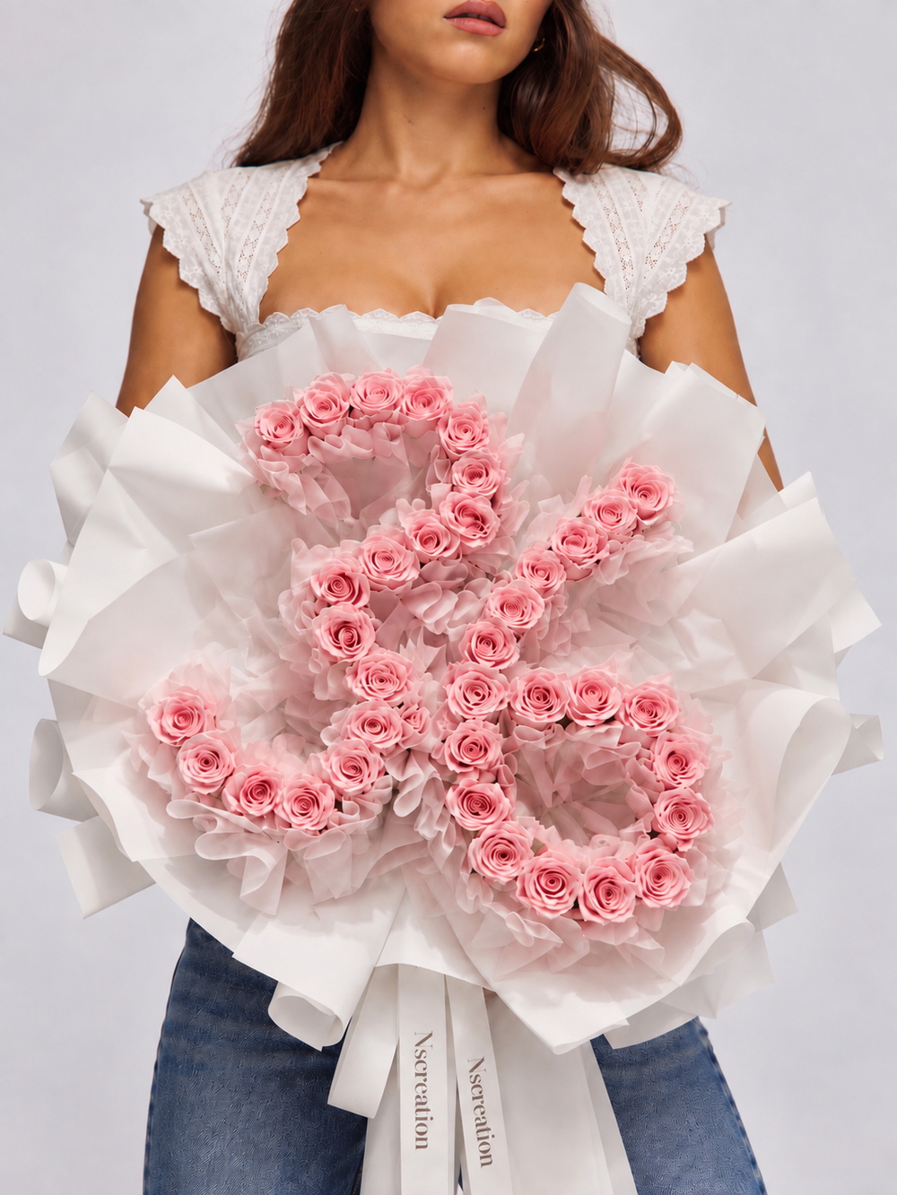 Bouquet Elana de roses roses fraîches dessinant un chiffre, porté par une femme, papier blanc