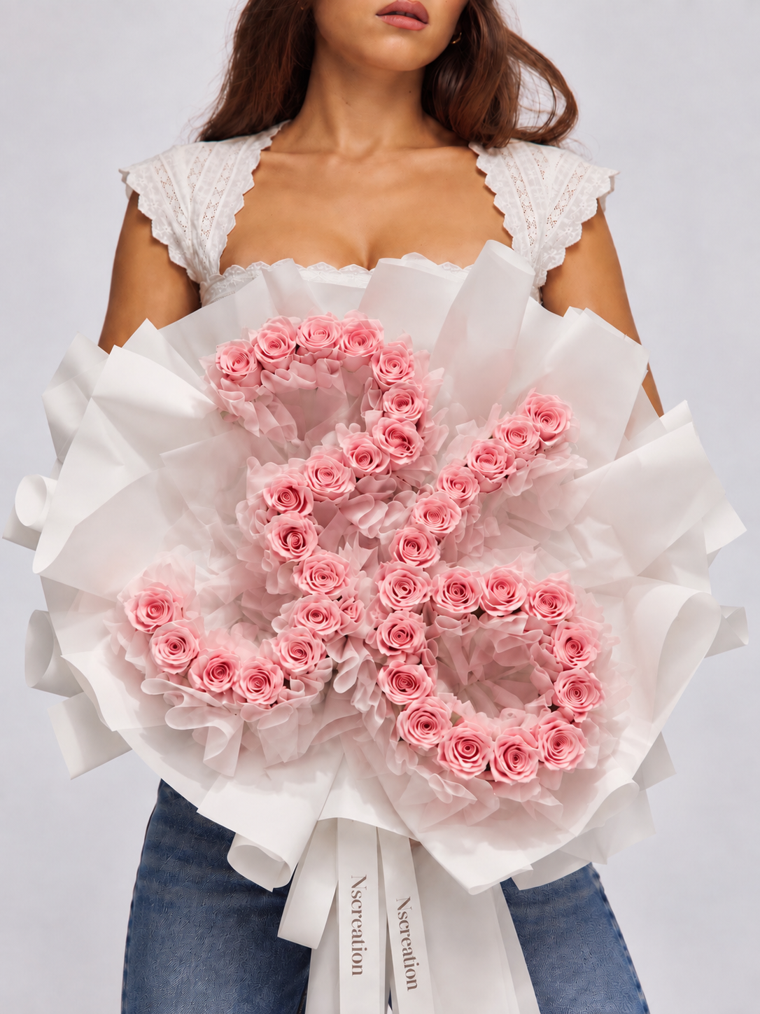 Bouquet Elana de roses roses fraîches dessinant un chiffre, porté par une femme, papier blanc