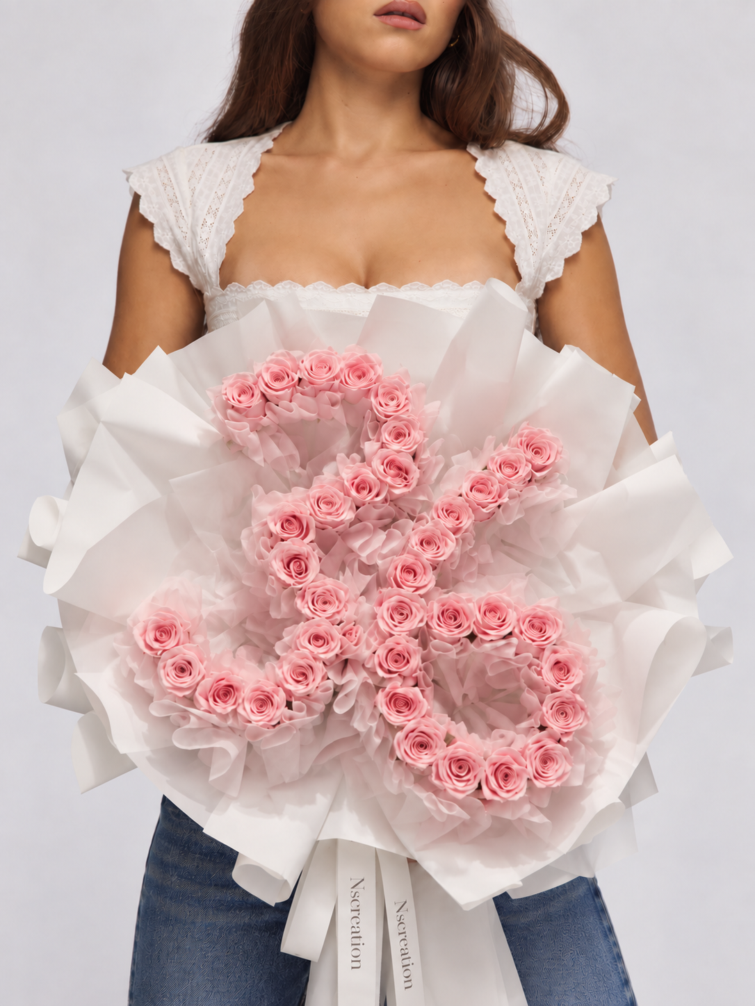 Bouquet Elana de roses roses en forme de chiffre tenu dans les bras, vue de face