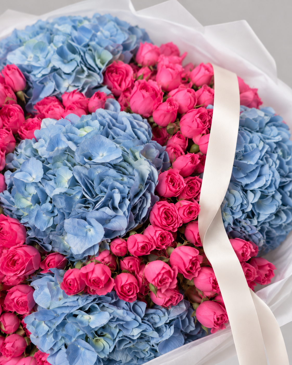 Gros plan sur les hortensias bleus et roses fuchsia du bouquet ELISABETTA
