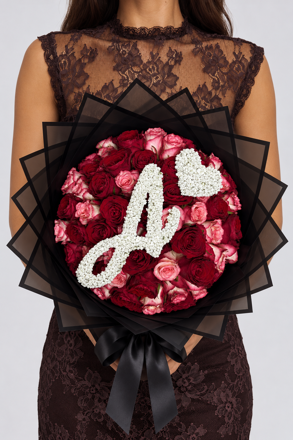Bouquet Esme de roses rouges et roses fraîches, vue de face avec nœud noir et lettre en gypsophile
