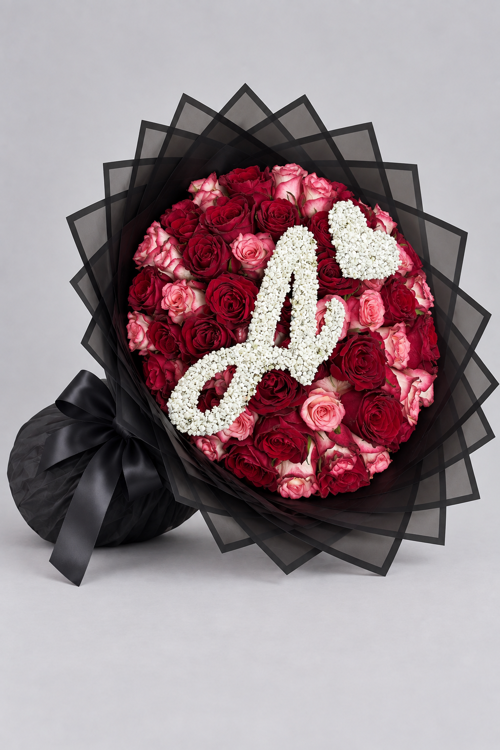Bouquet Esme de roses rouges et roses fraîches, vue de côté avec papier noir et nœud noir