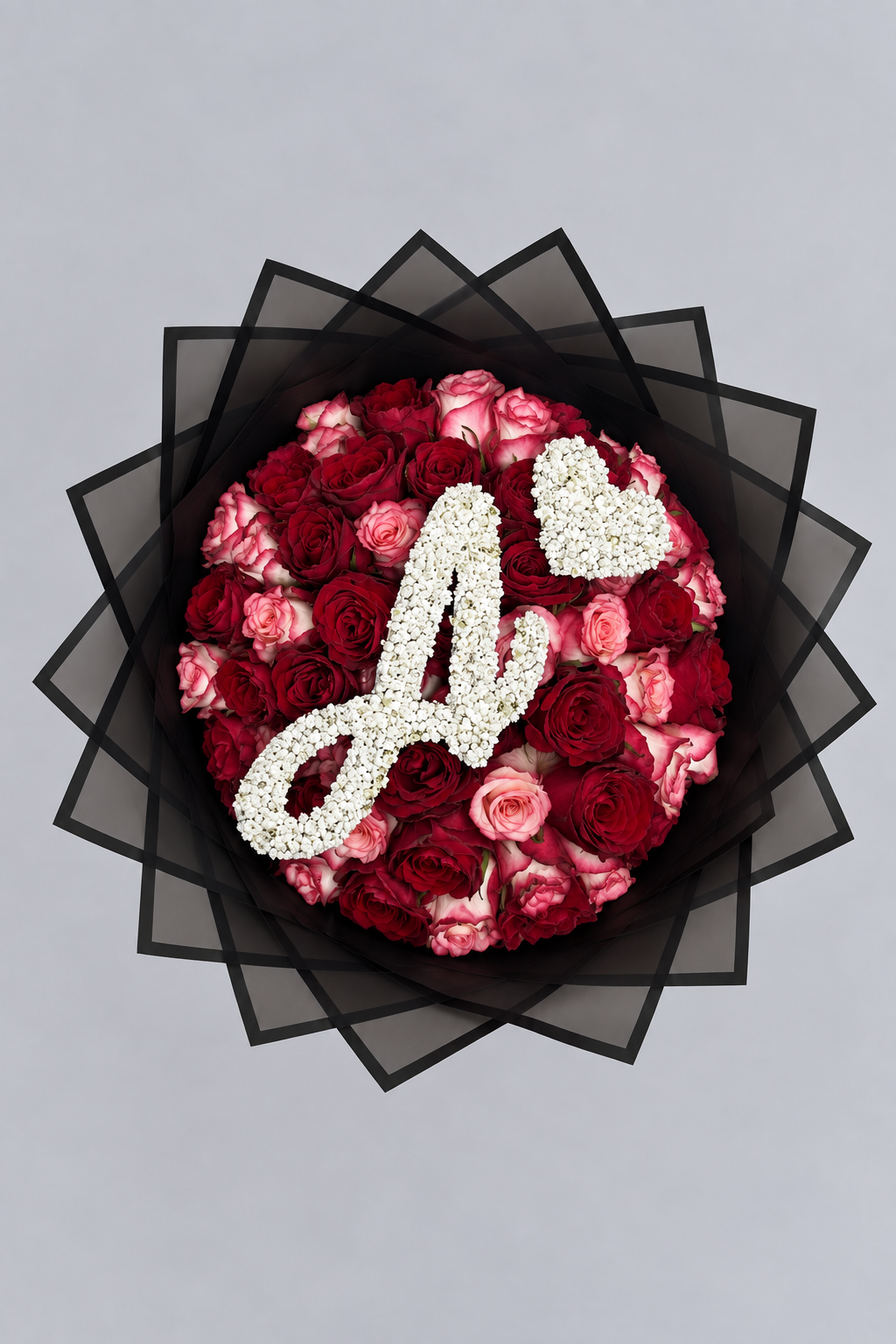 Bouquet Esme de roses rouges et roses fraîches vu de dessus avec lettre et cœur en gypsophile, fond gris