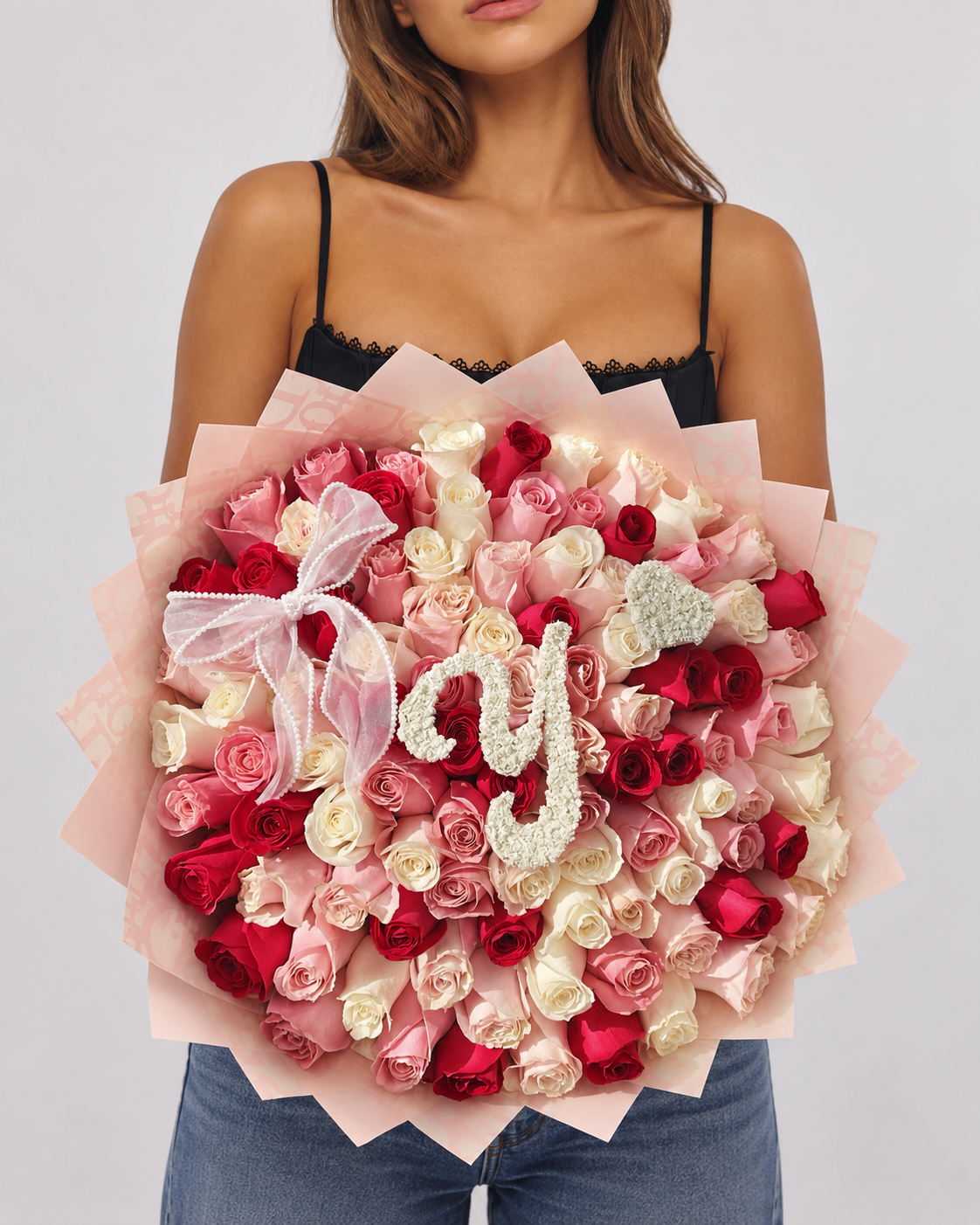 Bouquet Juliette de roses rouges, roses et blanches tenu dans les bras, vue de face
