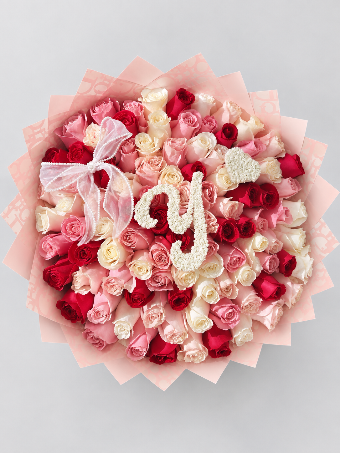 Bouquet Juliette de roses rouges, roses et blanches vu de dessus, papier rose plissé