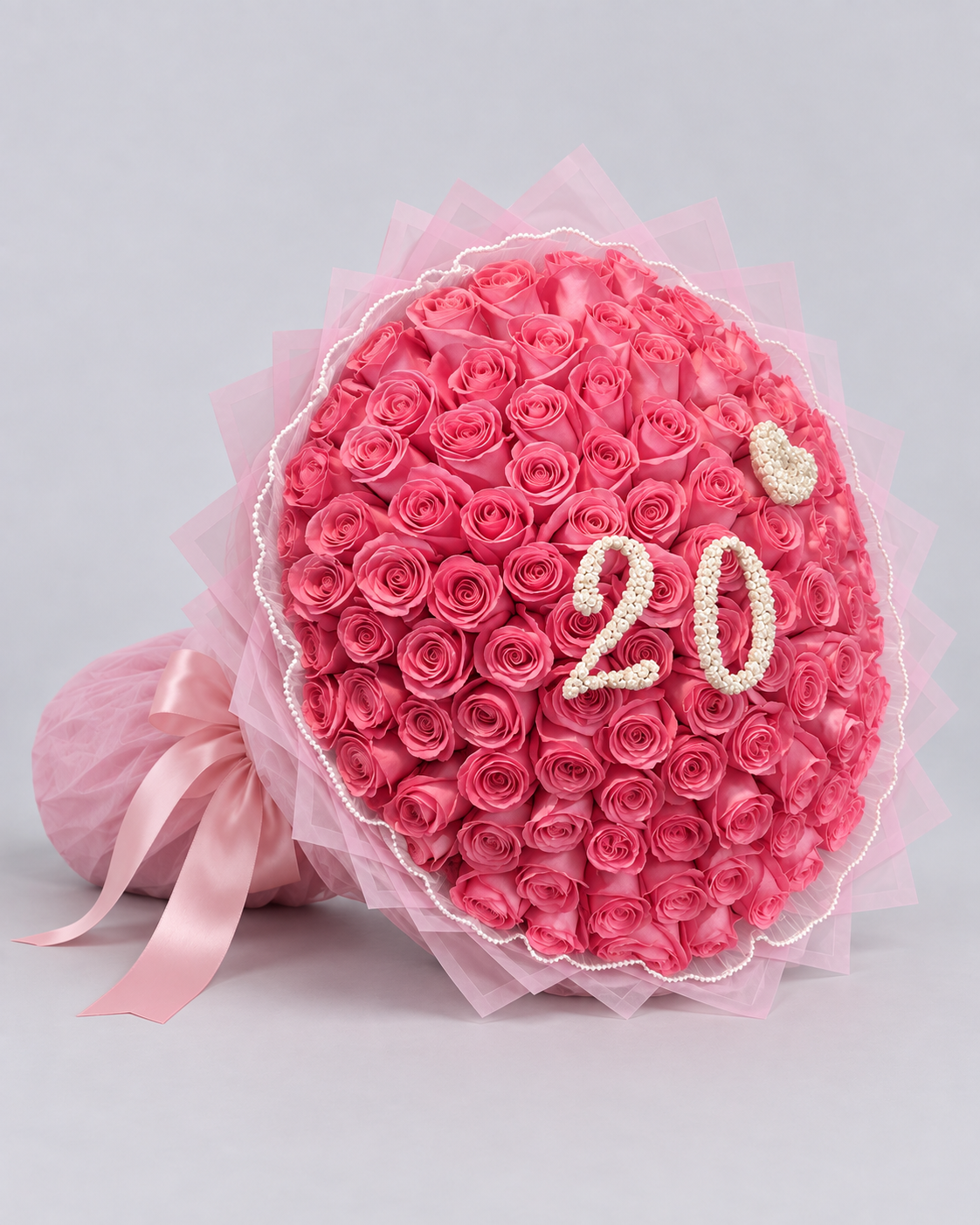 Bouquet Kikky de roses roses avec chiffre 20, papier transparent et ruban rose, vue de côté