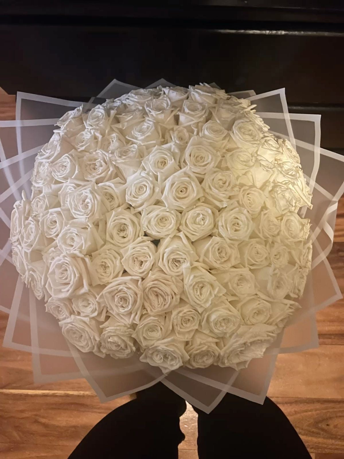 Grand bouquet Lyra de roses blanches fraîches en papier transparent, vu de côté