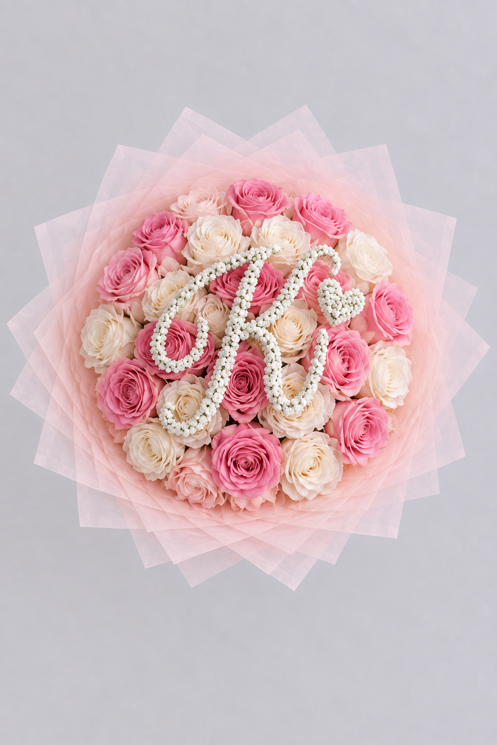 Bouquet Mademoiselle de roses blanches et roses fraîches vu de dessus avec lettre K en gypsophile