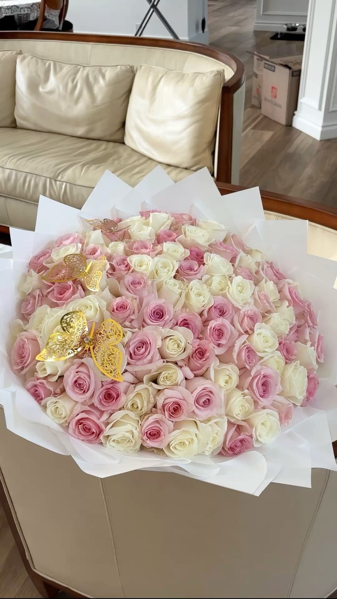 Grand bouquet Mademoiselle de roses blanches et roses fraîches, papier blanc, posé sur une table
