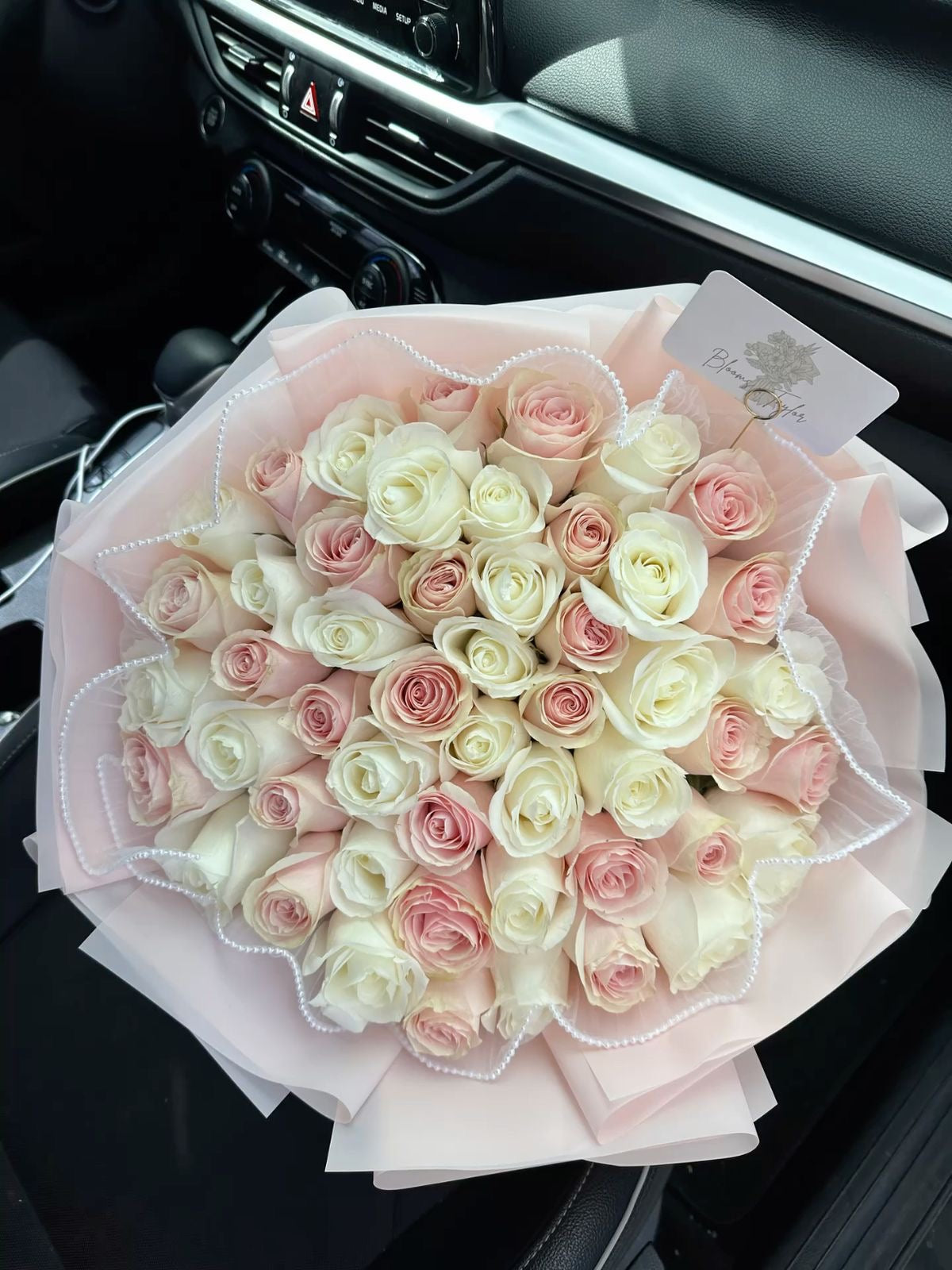 Bouquet Mademoiselle moyen de roses blanches et roses fraîches, papier rose pâle