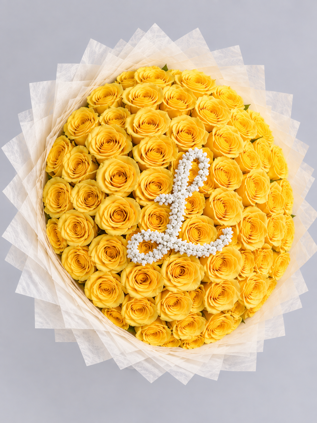 Bouquet Mia de roses jaunes avec lettre L vu de dessus, papier blanc crème