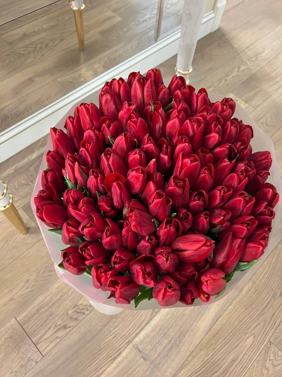 Bouquet Mira de tulipes rouges fraîches posé au sol dans un salon