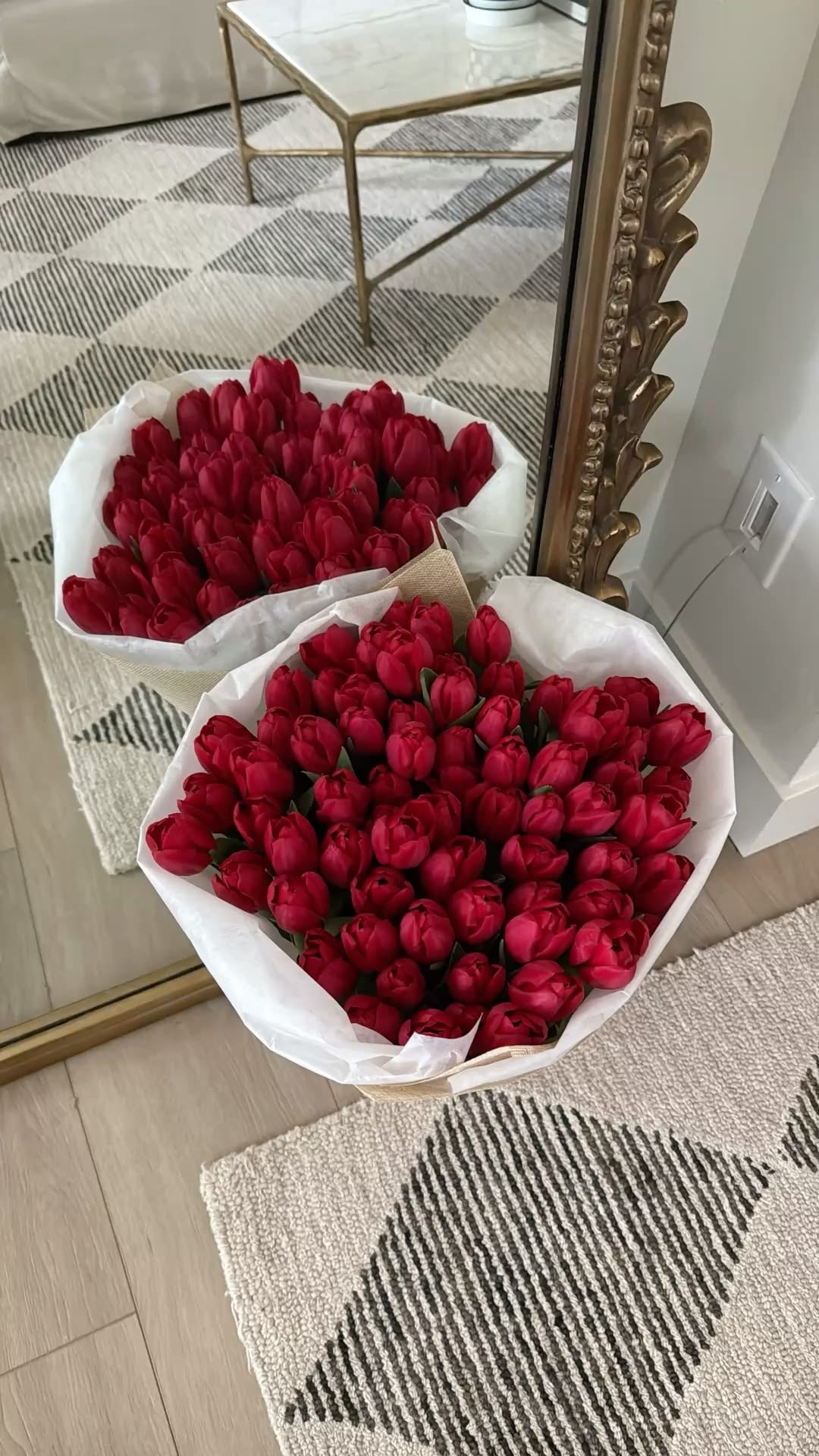 Deux bouquets Mira de tulipes rouges de tailles différentes devant un miroir