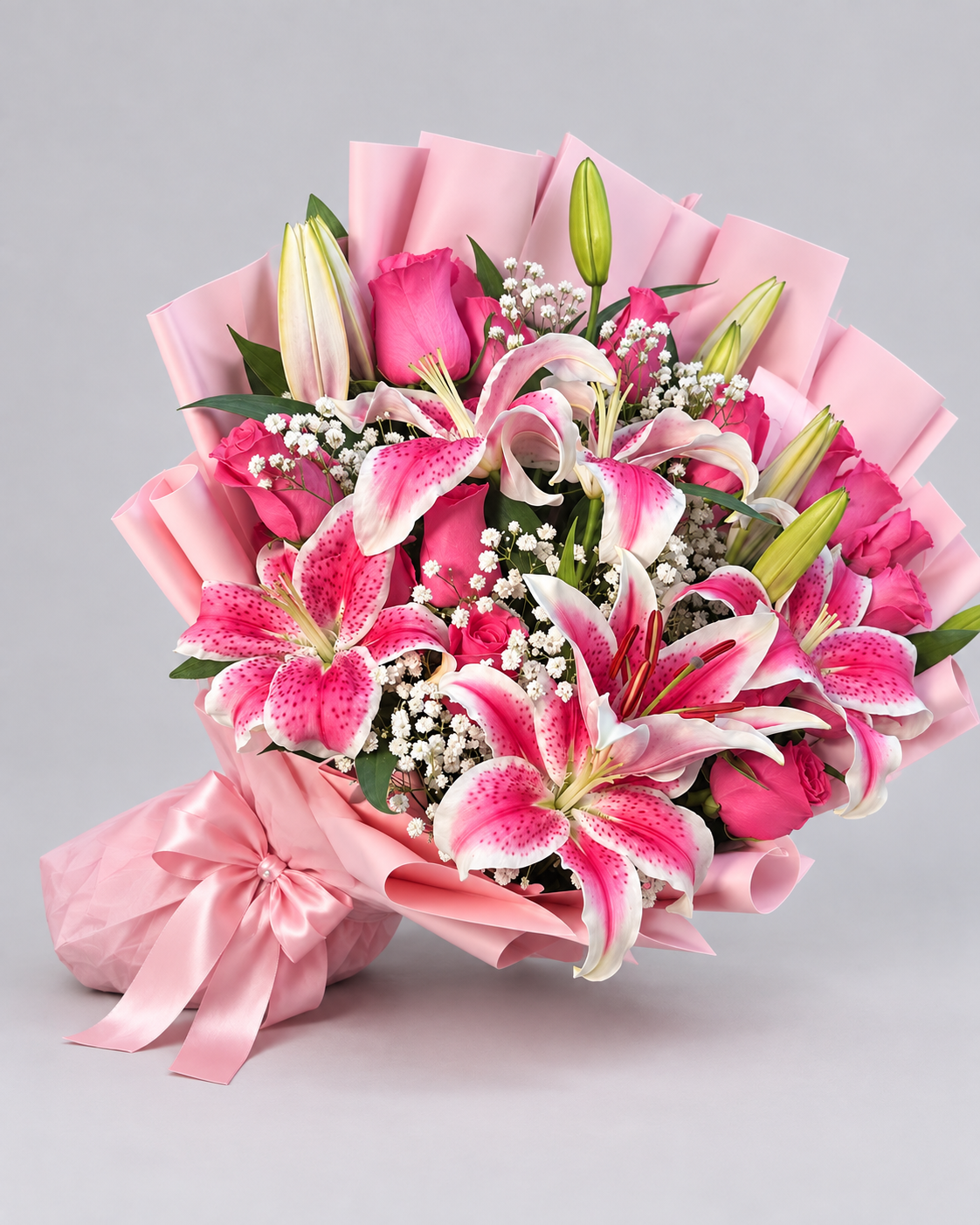 Bouquet Muse de lys roses posé sur fond clair avec ruban rose, vue de côté