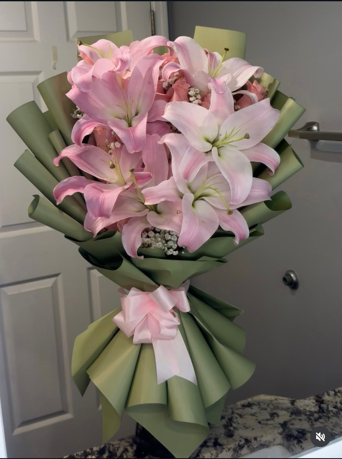 Bouquet Muse de lys roses dans un papier vert, variante d'emballage