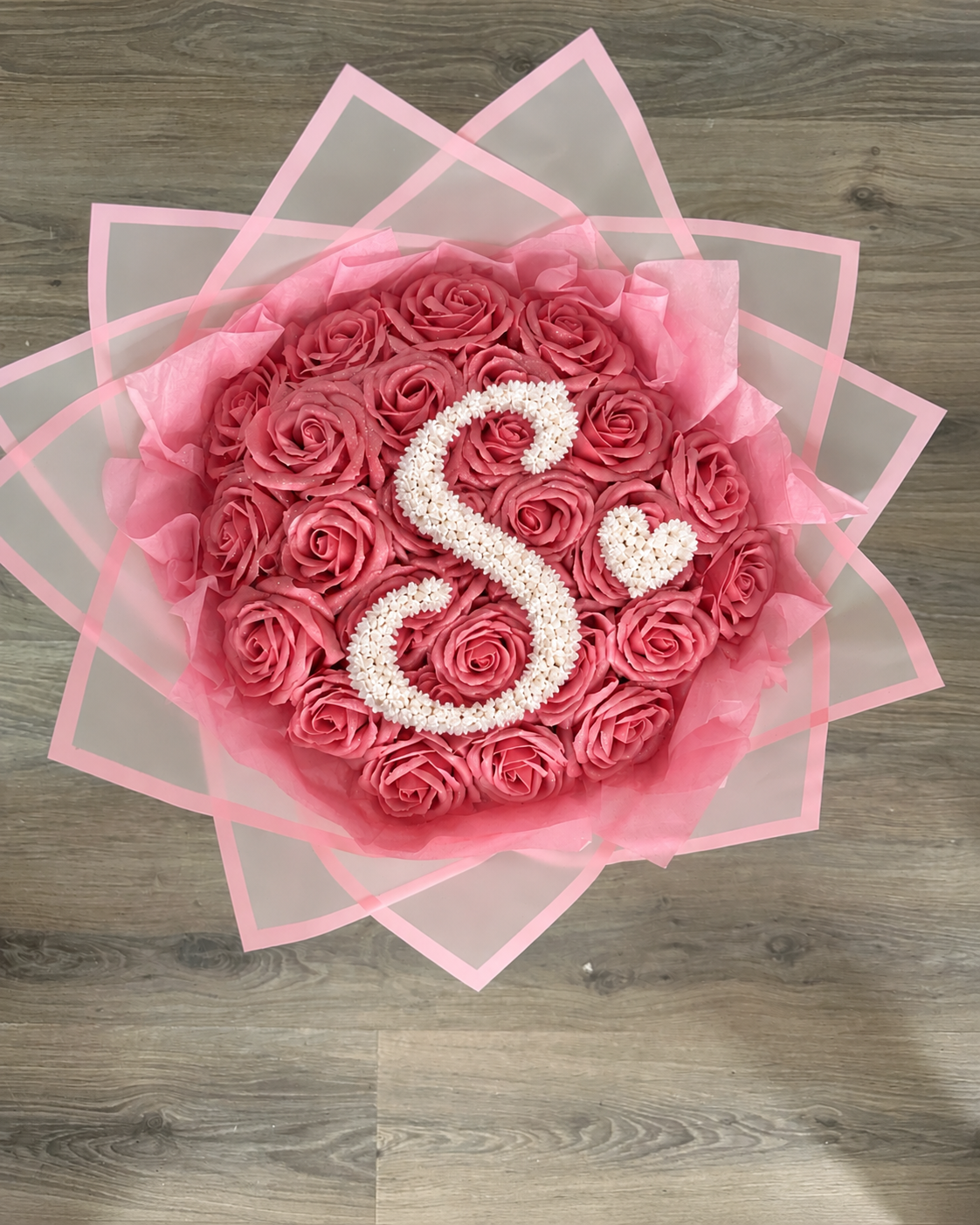 Bouquet NINA de 25 roses éternelles rose framboise posé sur fond neutre
