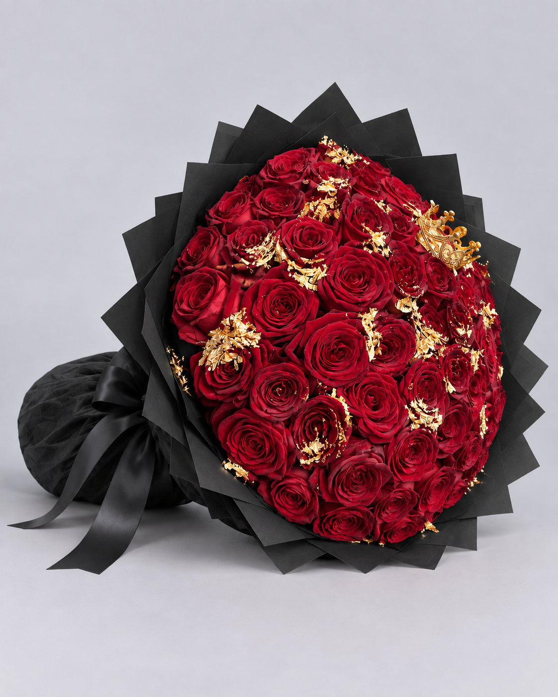 Bouquet ORNELA de roses rouges fraîches et feuilles d'or, vue de côté avec ruban noir