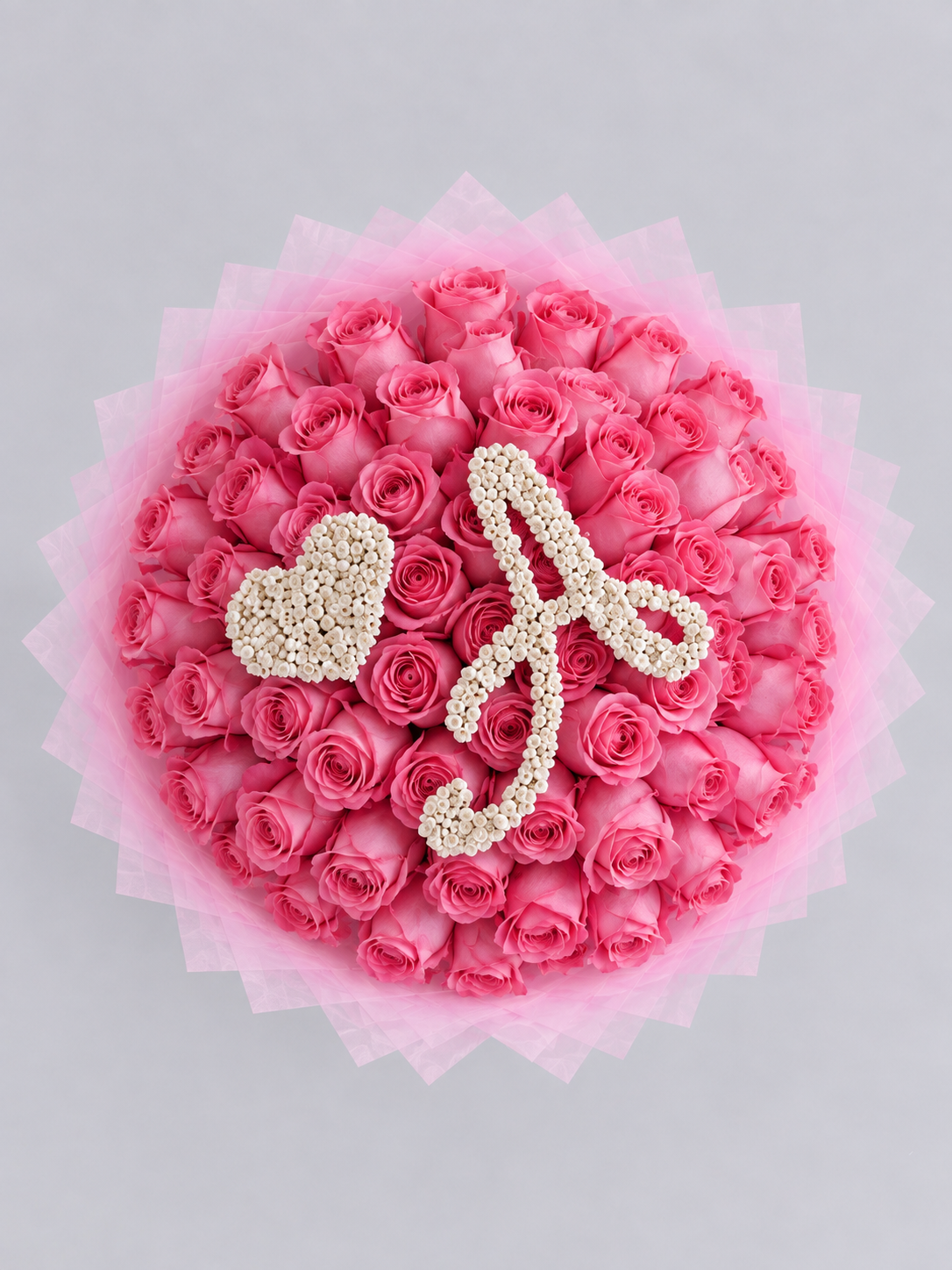 Bouquet Penelope de roses roses fraîches vu de dessus avec lettre A et cœur en gypsophile