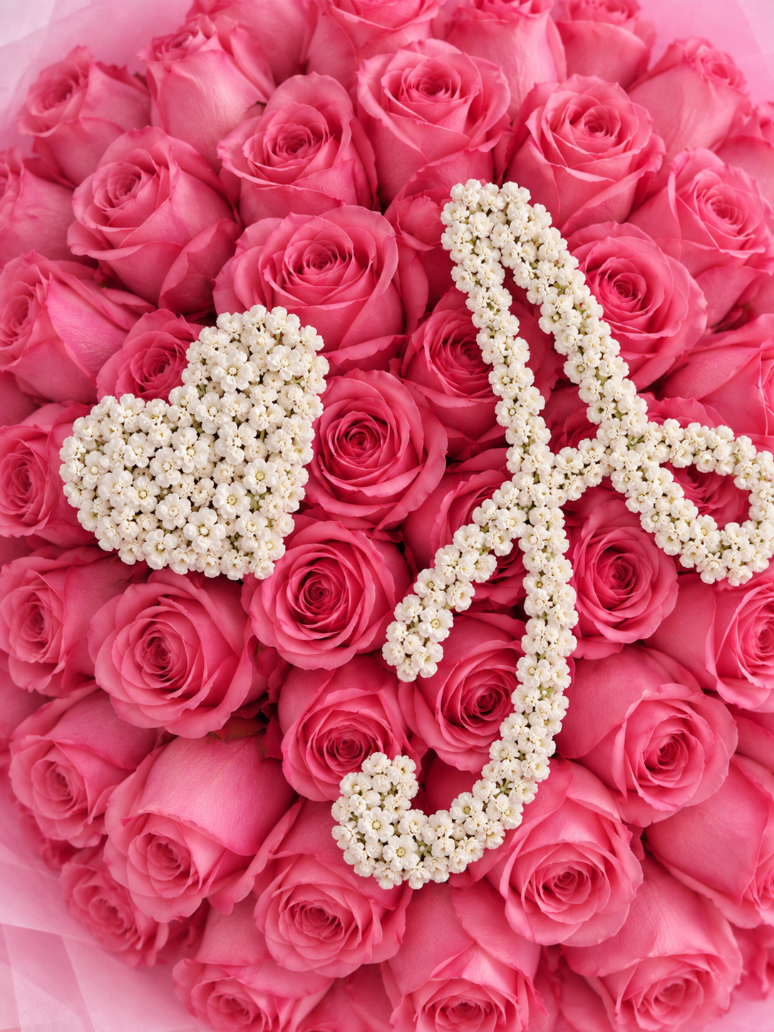 Détail de la lettre A et du cœur en gypsophile sur les roses roses du bouquet Penelope