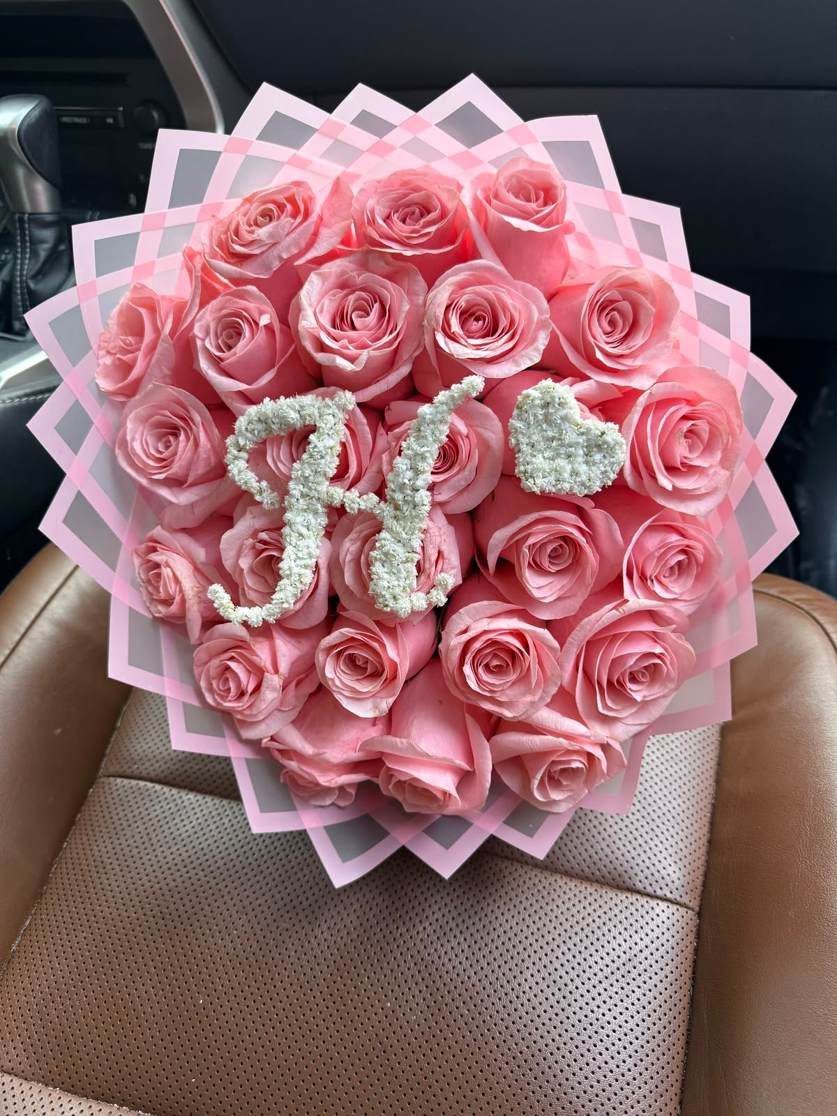 Bouquet Penelope de roses roses fraîches avec lettre H et cœur en gypsophile, sur un siège