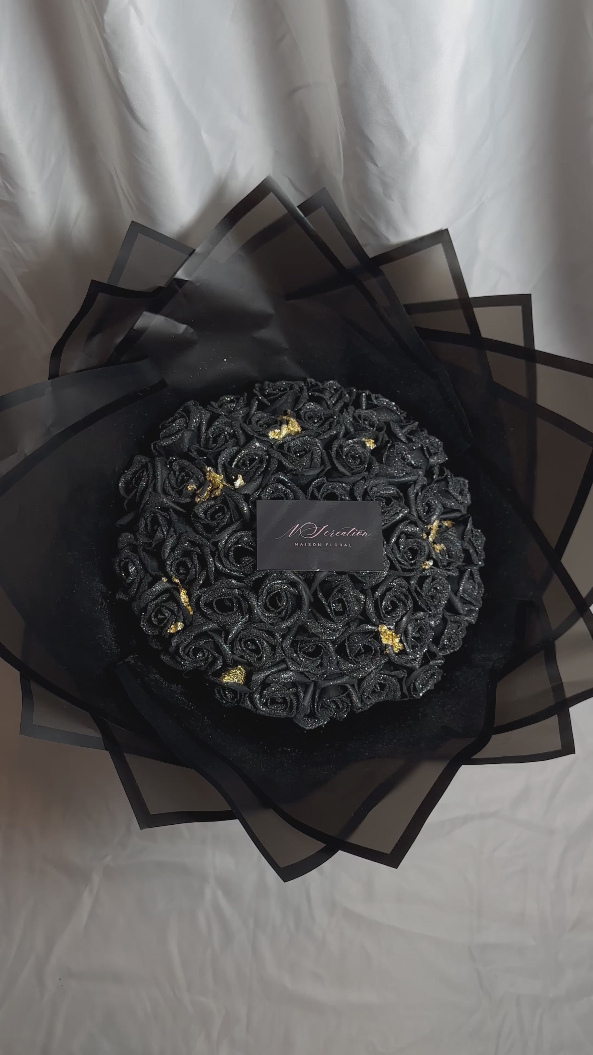 bouquet de roses noirs scintillants avec feuille d'or et emballage noir