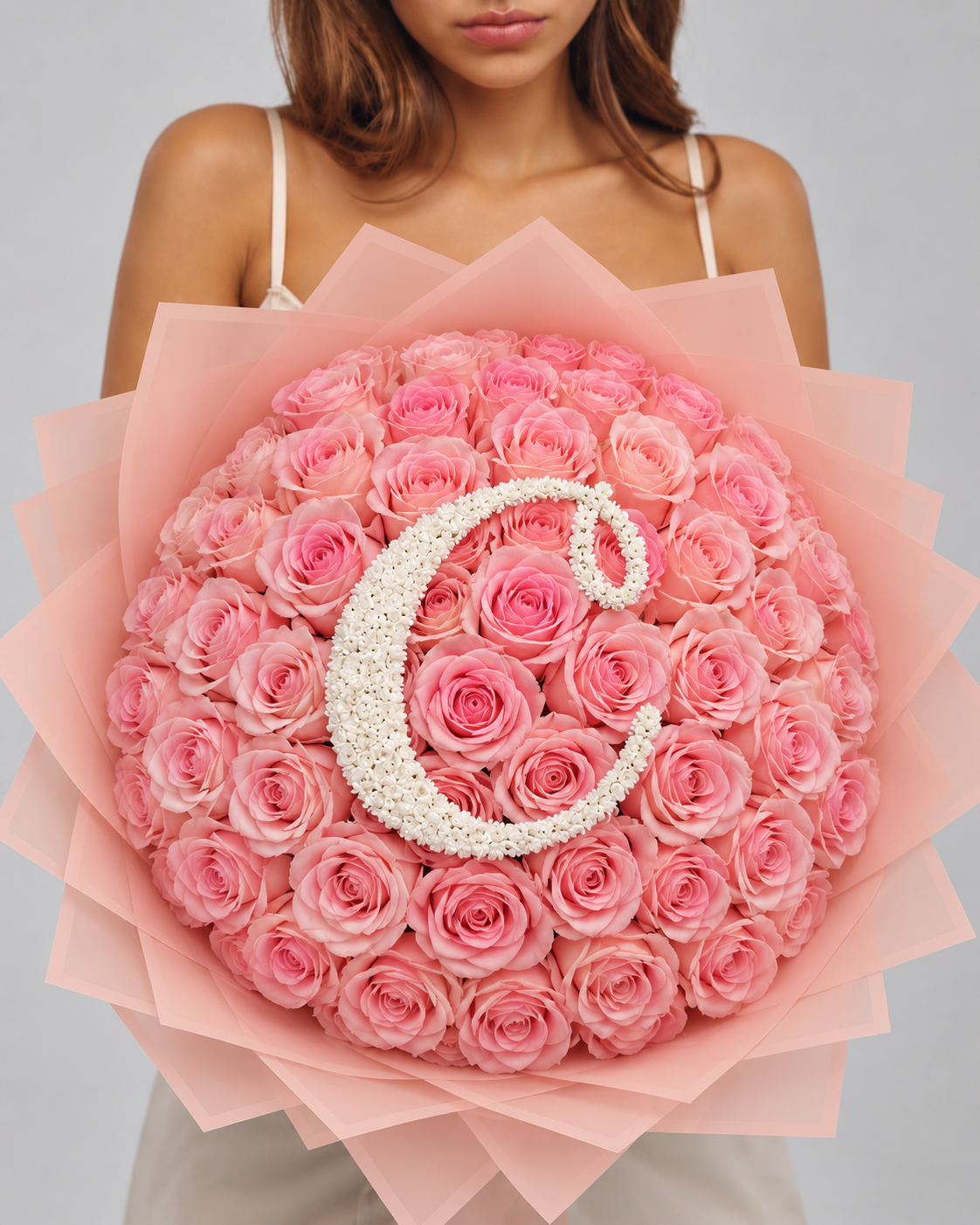 Bouquet SHAINEZ de roses éternelles roses avec lettre perlée, vue de face portée